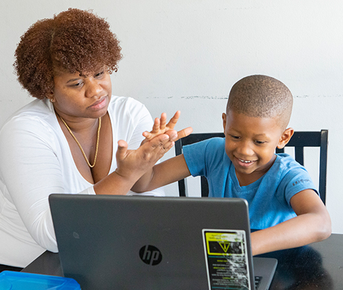 madre e hijo estudiando con el ordenador