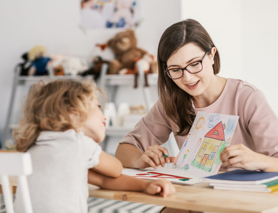 profesor enseñando un dibujo a una niña